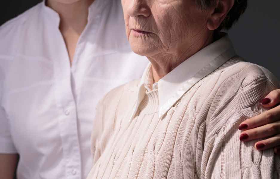 a carer comforting an elderly woman